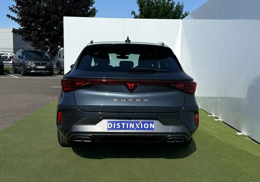 Vue arrière d'une CUPRA Leon Sportstourer gris magnétique avec signature lumineuse Tri-LED et double sortie d'échappement noire.