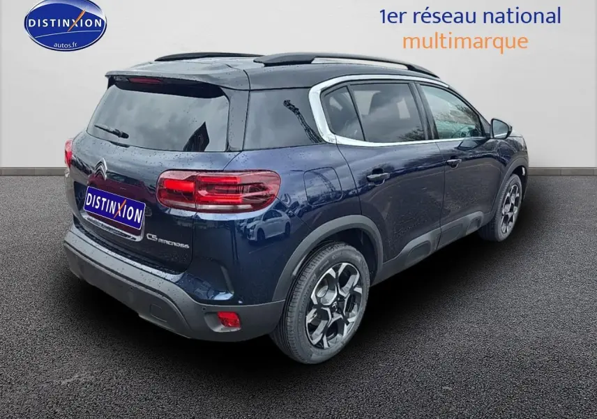 Vue 3/4 arrière droite d'un Citroën C5 Aircross bleu eclipse avec jantes alliage et vitres teintées.
