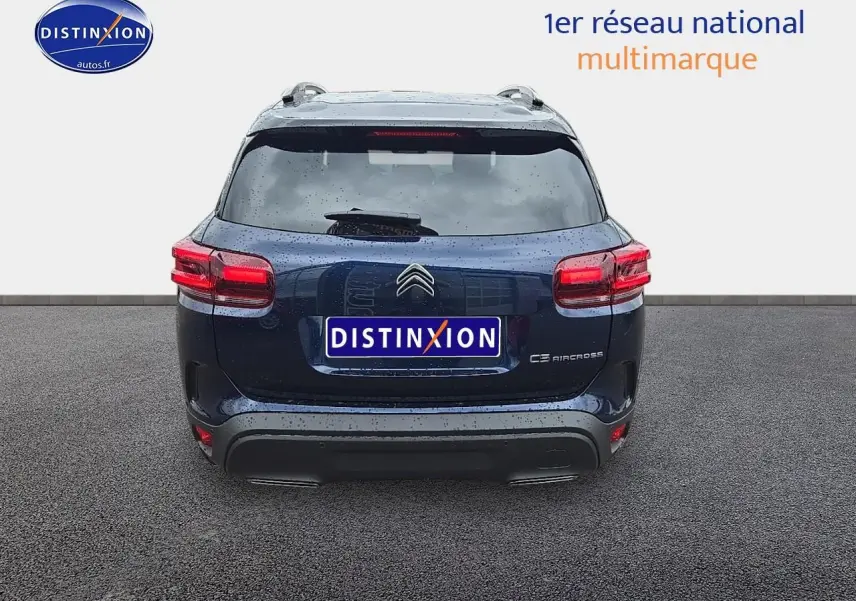 Vue arrière du Citroën C5 Aircross bleu eclipse 2025 avec feux rouges et logo distinctif sur fond gris.