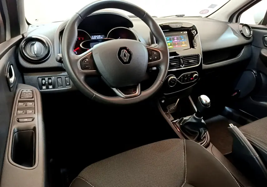 Intérieur de Renault Clio Business TCe 90 2019 vu côté conducteur, volant cuir et écran tactile central visible.