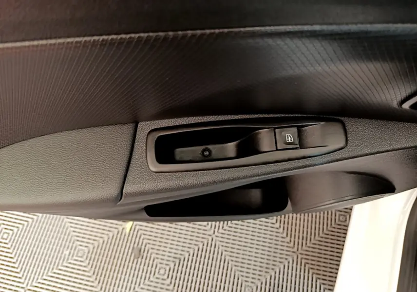 Gros plan sur la commande de lève-vitre côté conducteur de la Renault Clio Business TCe 90 blanche de 2019.