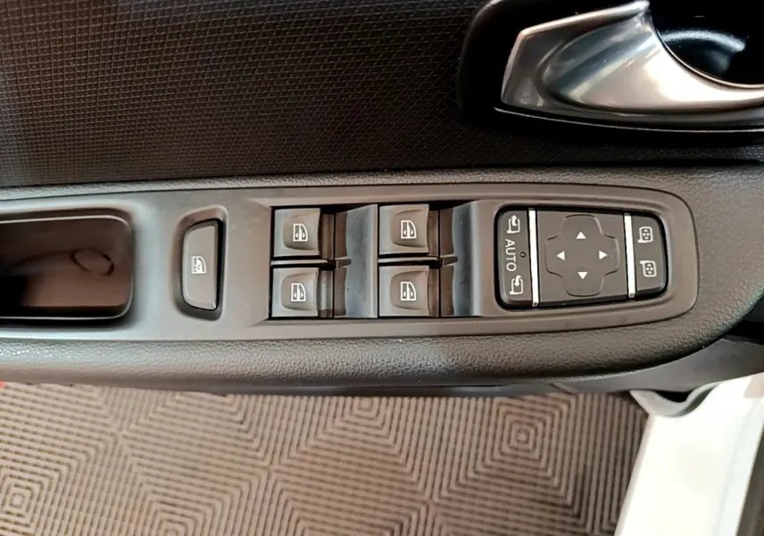 Vue rapprochée des commandes de lève-vitres et rétroviseurs sur la porte côté gauche d'une Renault Clio blanche 2019.