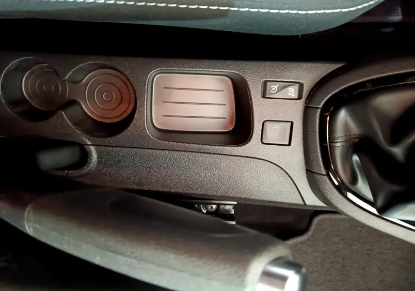 Gros plan sur la console centrale noire de la Renault Clio Business TCe 90 avec frein à main et commandes proches du levier de vitesses.