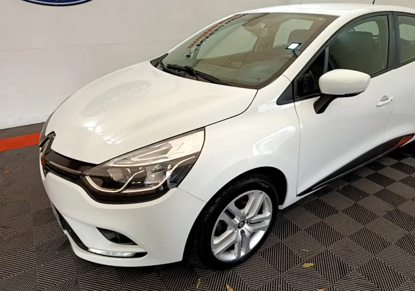Renault Clio Business TCe 90 blanche vue en 3/4 avant droit, avec phares LED et jantes alliage visibles.