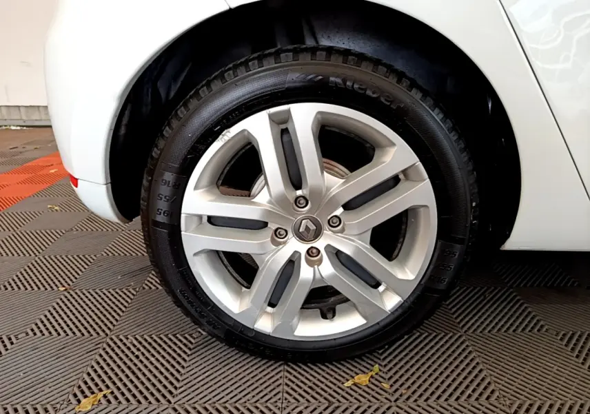 Vue rapprochée de l'aile arrière droite blanche d'une Renault Clio Business TCe 90 de 2019 sur sol carrelé.