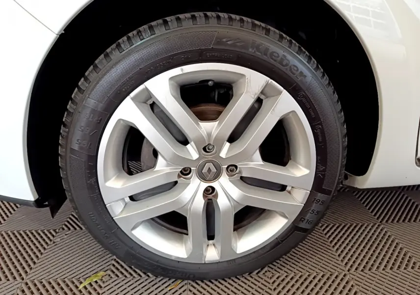 Gros plan sur la roue avant droite blanche d'une Renault Clio Business TCe 90 de 2019 avec jante alliage argentée.