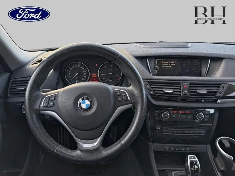 Vue intérieure du tableau de bord et volant cuir multifonction d'une BMW X1 xDrive25dA 2014 en Mineralgrau.