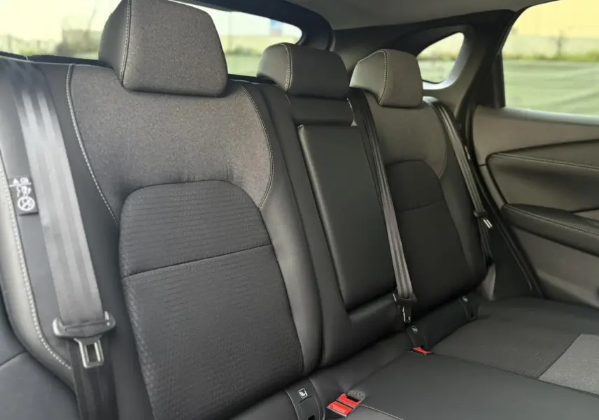 Vue intérieure du siège arrière du Nissan Qashqai gris Ceramic, montrant les trois appuie-têtes et les ceintures de sécurité.