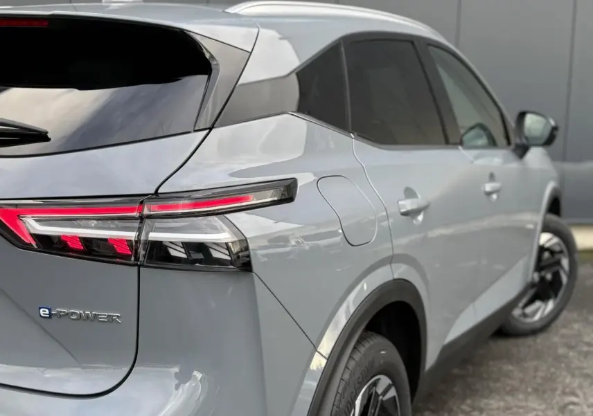 Vue 3/4 arrière droite du Nissan Qashqai III e-Power gris Ceramic avec feux arrière LED et badges distinctifs e-POWER.