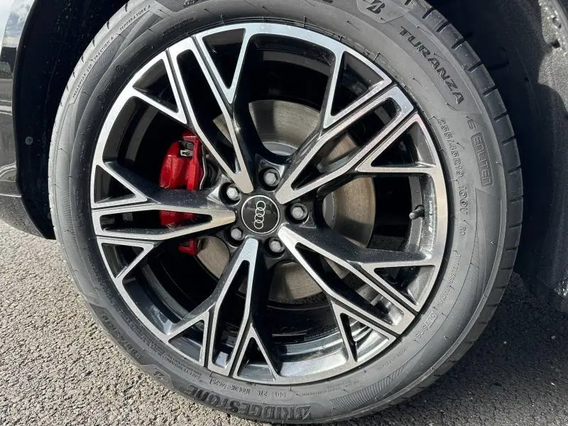 Gros plan sur la jante alu noire et argentée d’un Audi Q3 2.0 TDI 150ch, avec étrier de frein rouge visible.