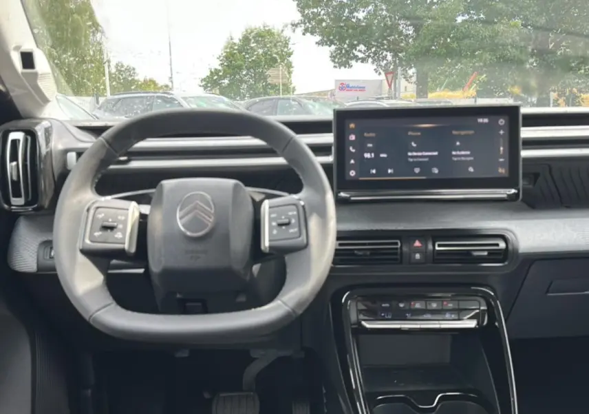 Vue intérieure frontale du tableau de bord et volant gris du Citroën C3 Aircross avec écran tactile central et commandes au volant.