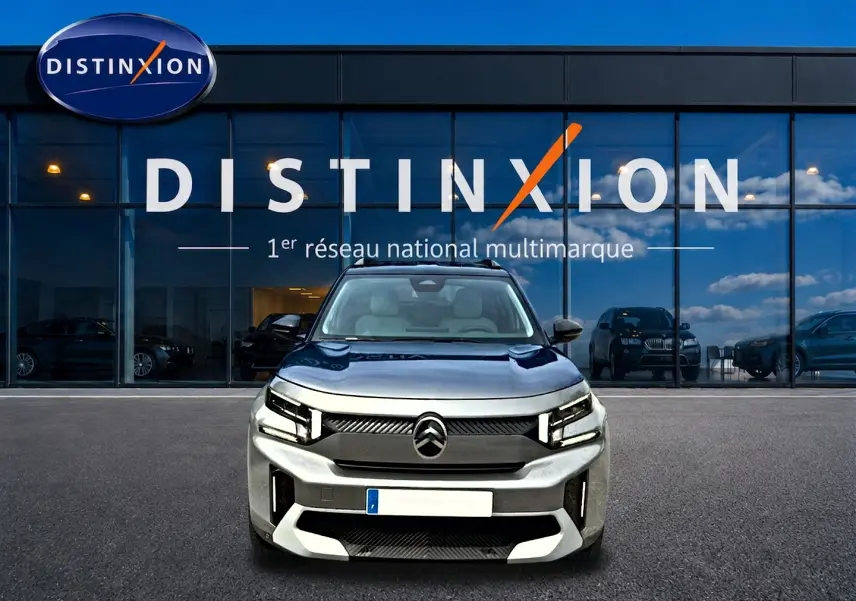 Citroën C3 Aircross gris mercury vue de face, avec calandre noire et phares LED distinctifs, devant showroom Distinxion.