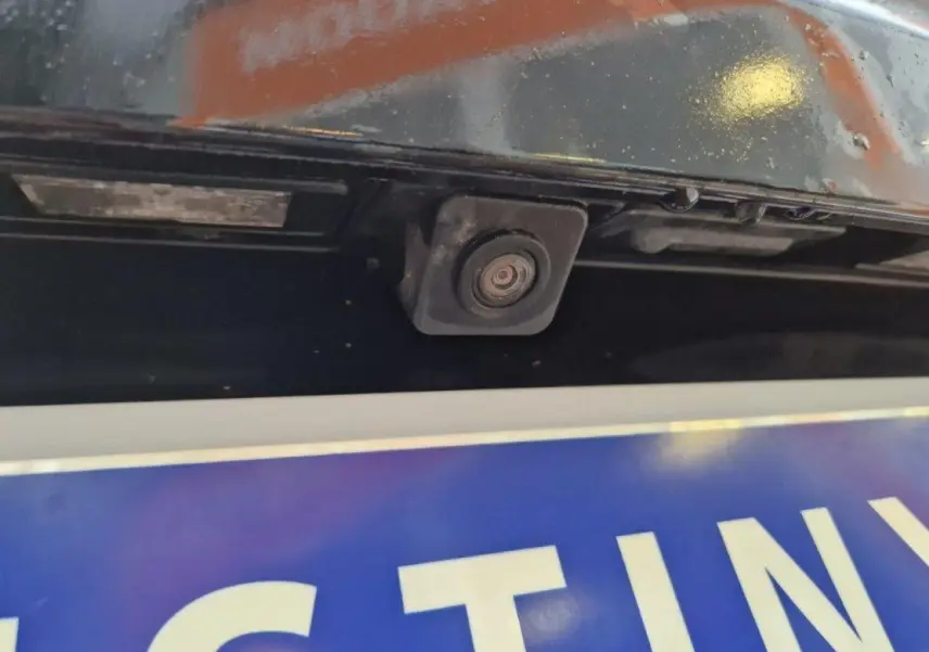 Gros plan sur la caméra de recul intégrée au hayon arrière d’un Peugeot 3008 noir de 2019.