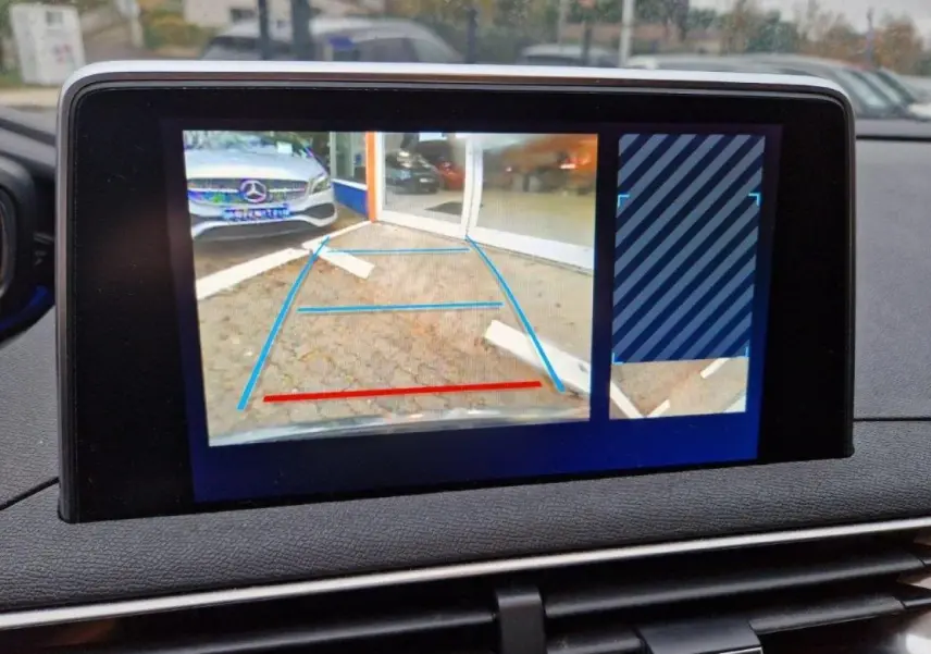 Écran tactile du Peugeot 3008 noir montrant la caméra de recul avec aides au stationnement activées.