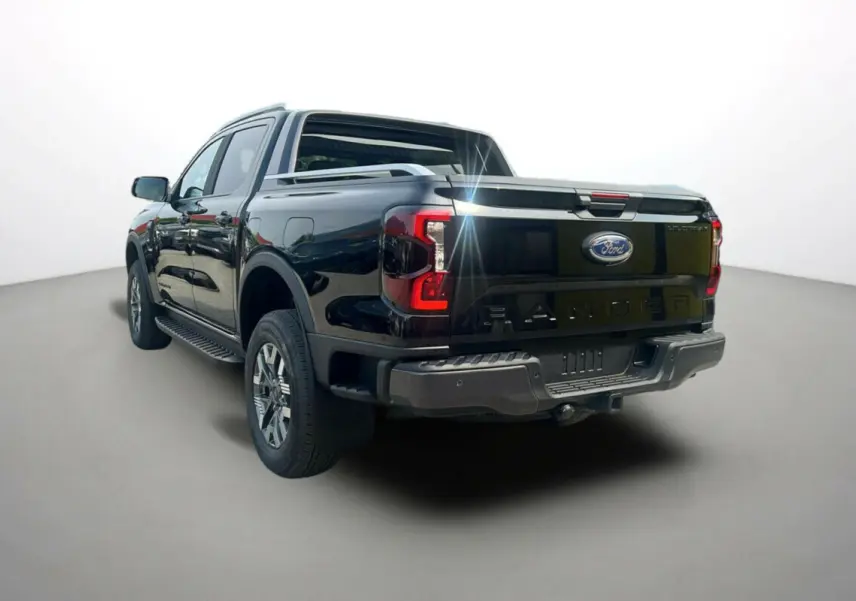 Vue 3/4 arrière du Ford Ranger 2025 noir agate, mettant en valeur la benne et les feux arrière distinctifs Wildtrak Plus.