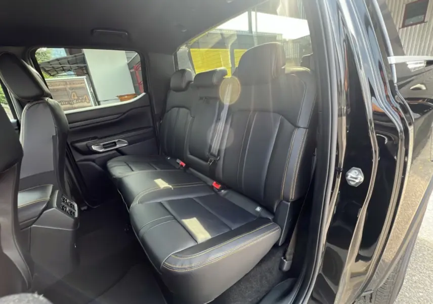 Vue intérieure côté droit sur la banquette arrière en cuir noir avec surpiqûres jaunes du Ford Ranger 2025 Wildtrak Plus.