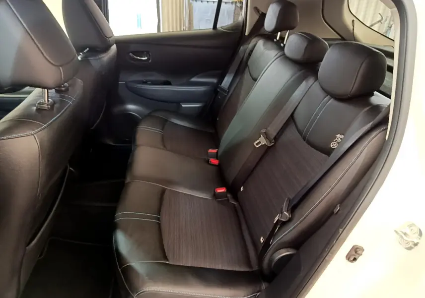 Vue côté droit de la banquette arrière noire avec surpiqûres bleues du Nissan Leaf blanc 62 kWh Business+ 2020 électrique.