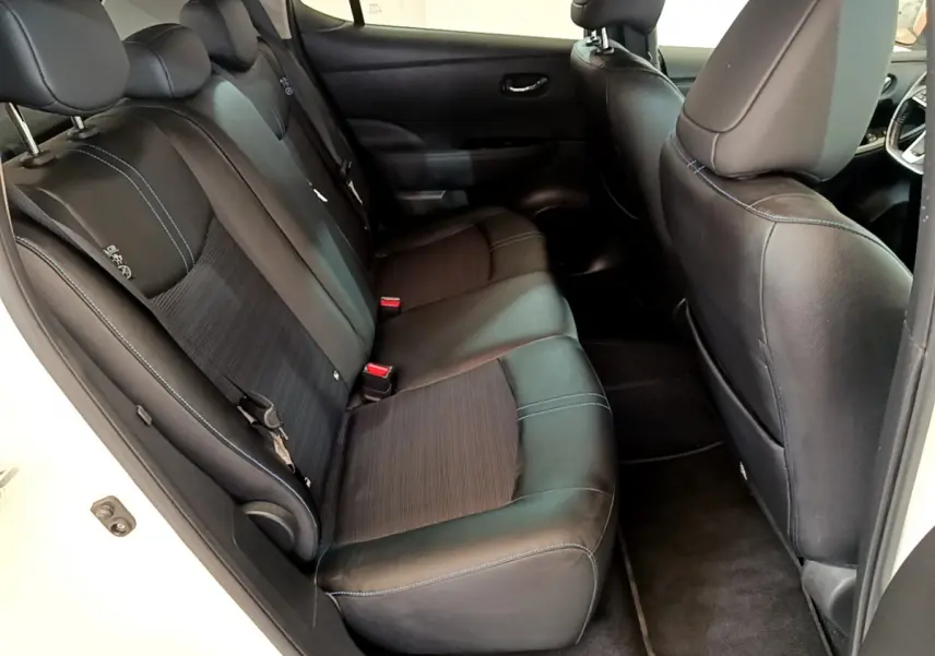 Vue intérieure côté gauche des sièges arrière noirs avec surpiqûres bleues d'une Nissan Leaf 62 kWh Business+ blanche de 2020.