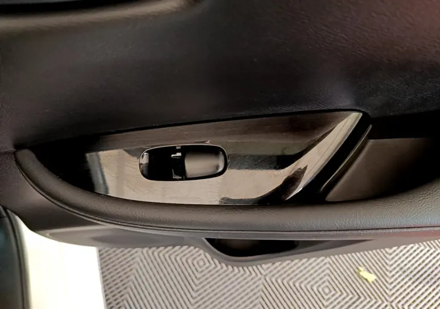 Poignée intérieure côté gauche noire brillante de la Nissan Leaf 62 kWh Business+ blanche, vue rapprochée.