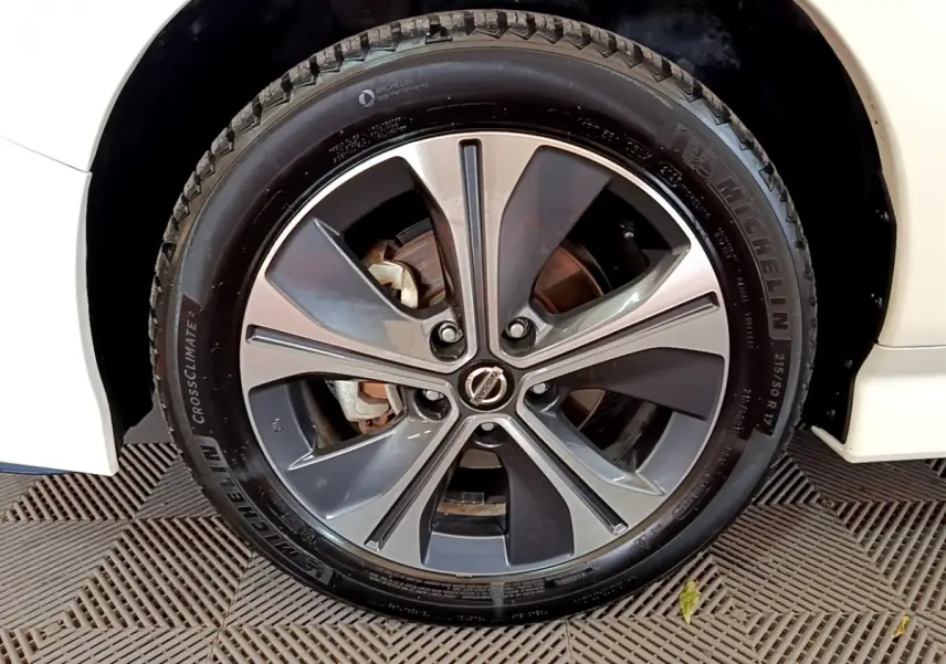 Gros plan sur la roue avant droite d'une Nissan Leaf blanche 2020 avec jante alliage bicolore et pneu Michelin