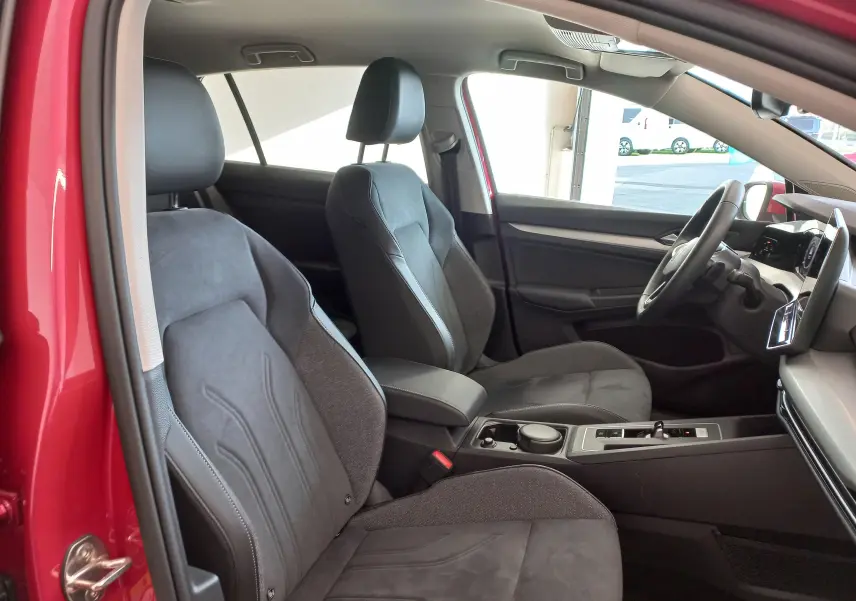 Intérieur avant droit d'une Volkswagen Golf 2.0 TDI rouge Roi, sièges chauffants et volant cuir multifonction visible.
