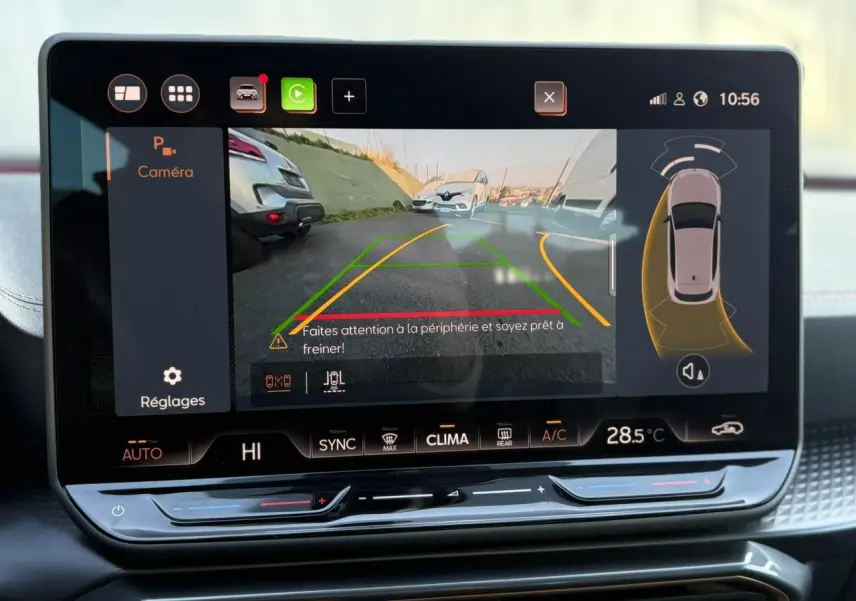 Écran tactile HD 12,9'' montrant la caméra de recul et l'aide au stationnement dans l'habitacle d'une CUPRA Leon blanche.