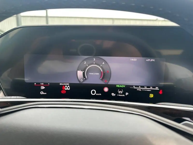 Vue de face sur le tableau de bord numérique de l'Audi Q3 gris 2026, affichant le compte-tours et les informations de conduite.