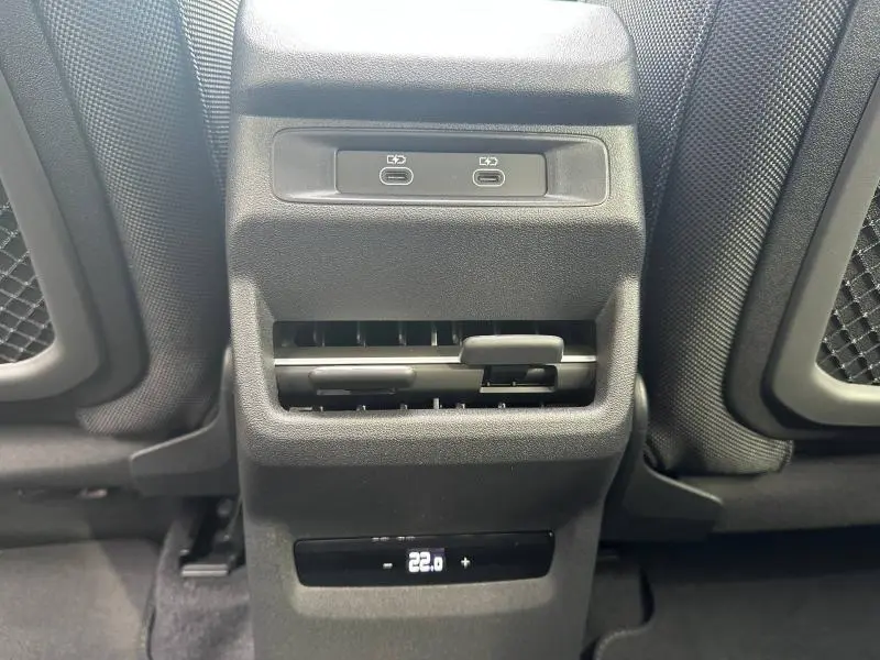 Vue rapprochée de la console arrière de l'Audi Q3 2026 gris, avec ports USB-C et réglage de la climatisation à 22°C.