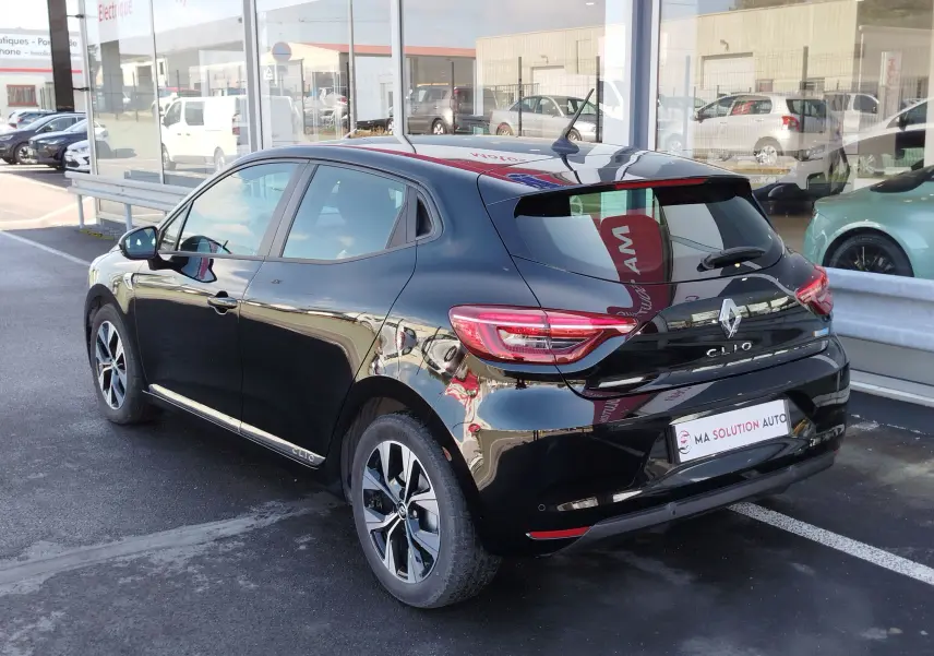Vue 3/4 arrière droite d'une Renault Clio 1.6 E-Tech noir étoile, avec jantes alliage et feux arrière LED distinctifs.