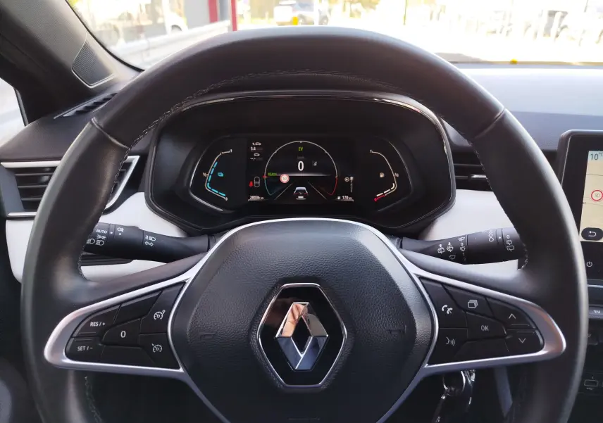 Vue rapprochée du volant noir de la Renault Clio 1.6 E-Tech 140ch Limited 2022 avec tableau de bord numérique allumé.