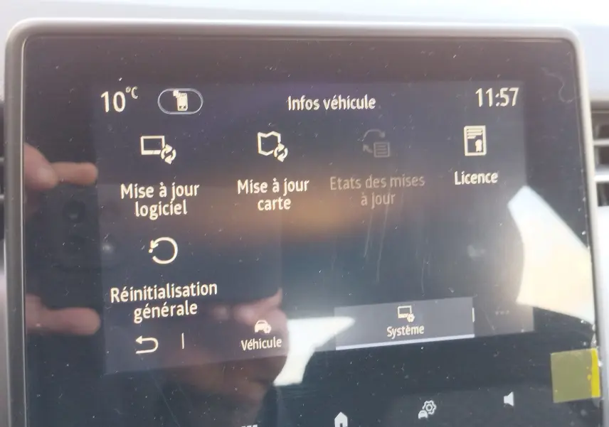 Écran tactile du système multimédia de la Renault Clio 1.6 E-Tech noir, affichant les options de mise à jour et réinitialisation.