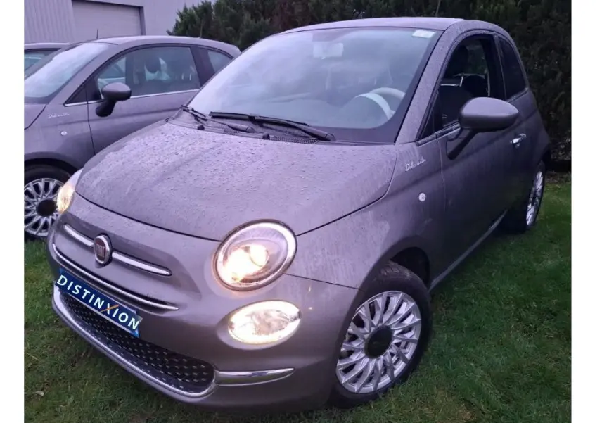 Vue 3/4 avant droite d'une Fiat 500 Gris Electroclash 2022 avec phares allumés et jantes spécifiques Dolcevita.