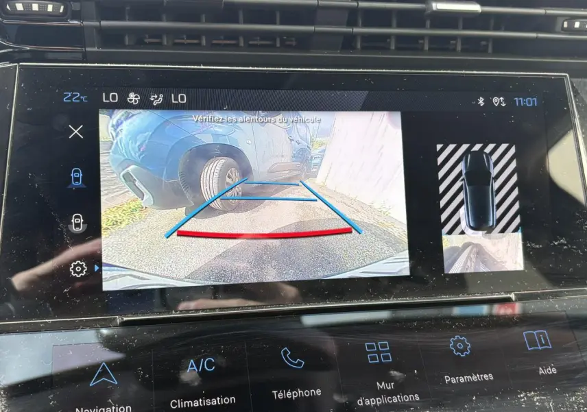 Écran tactile central montrant la caméra de recul avec vue arrière d’une Peugeot 308 Bleu Obsession en stationnement.