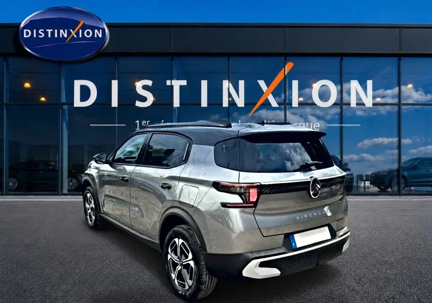 Vue 3/4 arrière droite du Citroën C3 Aircross gris mercury avec toit noir et jantes alu distinctives.