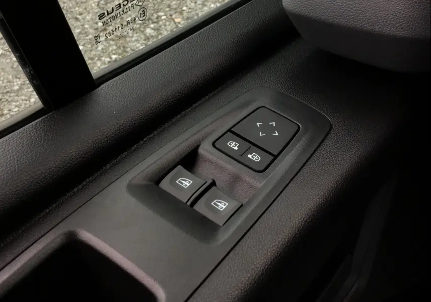 Commandes électriques des vitres et rétroviseurs sur la porte côté conducteur d'un Renault Master blanc 2025.
