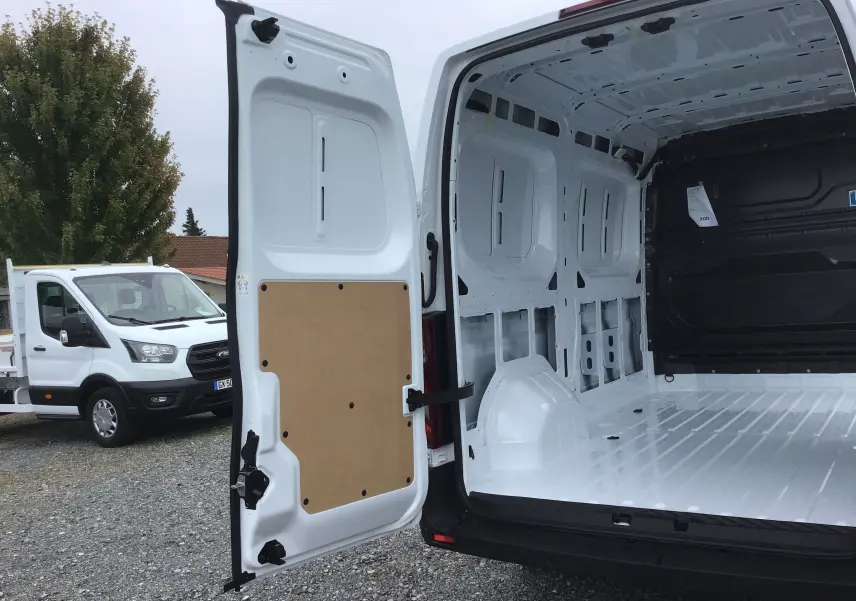 Vue arrière ouverte du Renault Master blanc montrant l'espace de chargement vide et la porte arrière gauche ouverte.