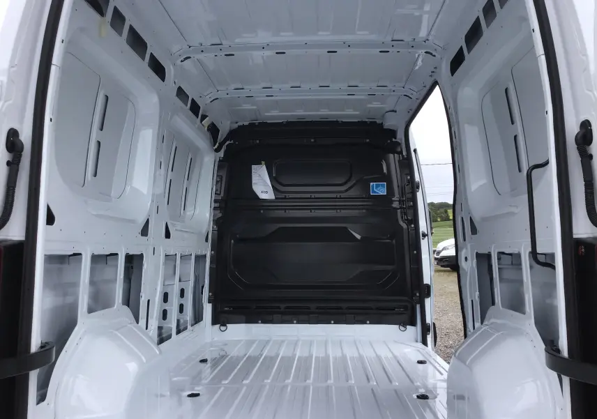 Intérieur vide du Renault Master blanc L2H2 vu de l'arrière, montrant la cloison noire et la structure métallique.