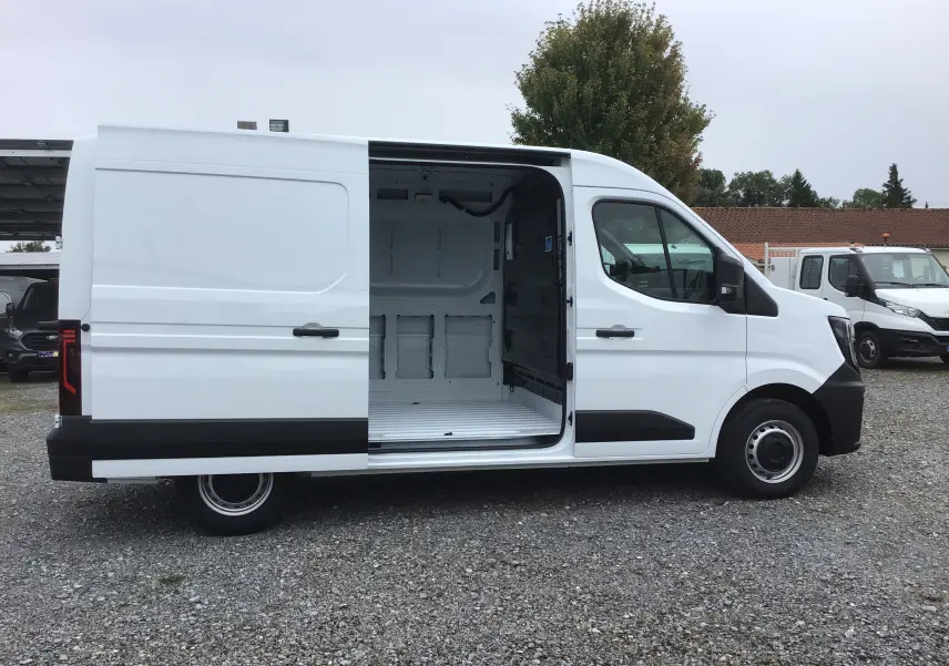Profil droit du Renault Master blanc 2025 avec porte latérale coulissante ouverte dévoilant l'espace de chargement vide.