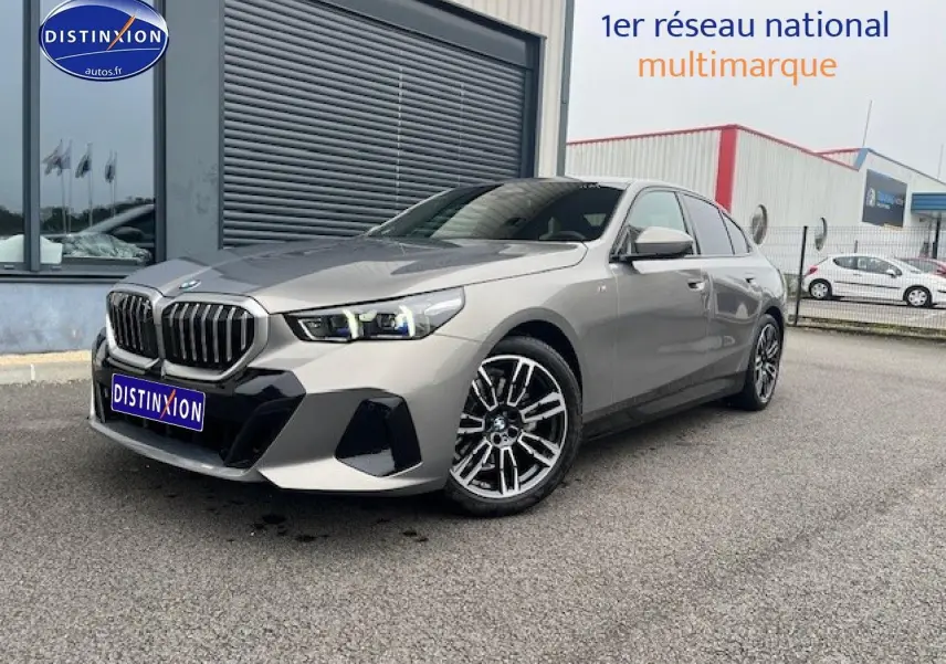 BMW Série 5 (G60) 520da gris vue 3/4 avant droit avec jantes alu et calandre imposante.