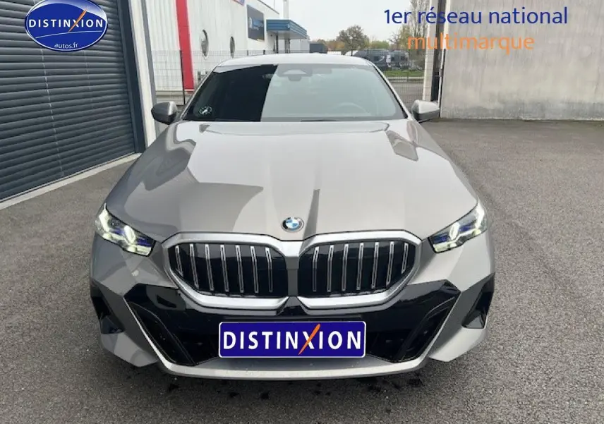 Vue frontale d'une BMW Série 5 gris métallisé (520da M Sport) avec calandre imposante et phares LED allumés.