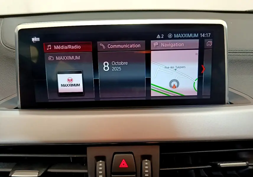 Écran central du tableau de bord du BMW X2 blanc 2023 affichant navigation, communication et média.