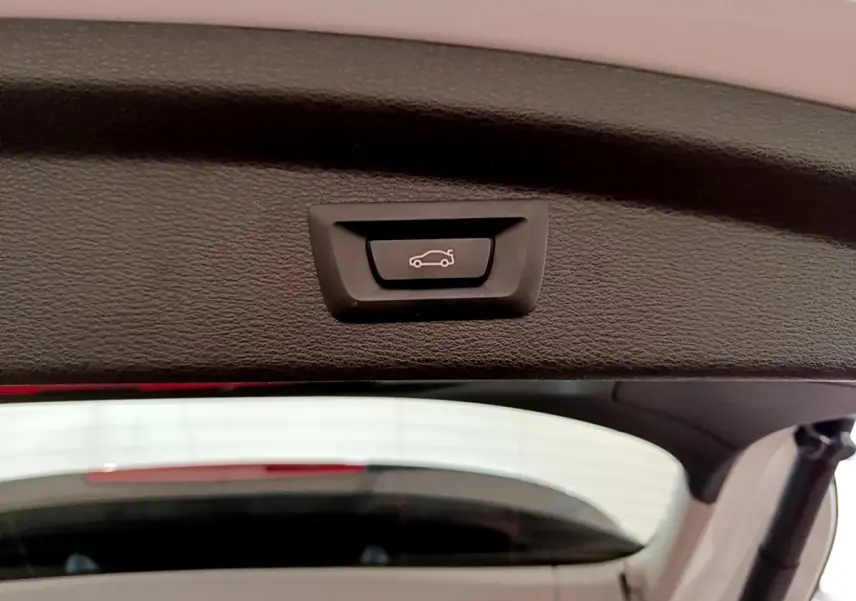 Bouton d'ouverture électrique du coffre sur la partie intérieure du hayon d'un BMW X2 blanc 2023.