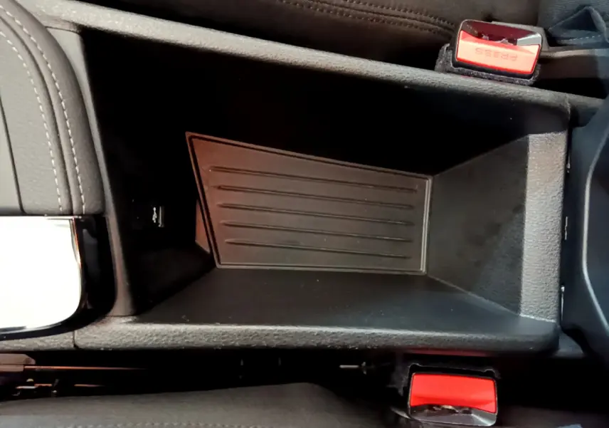 Vide-poche central noir avec ceintures de sécurité rouges dans l'habitacle d'une BMW X2 blanche 2023.
