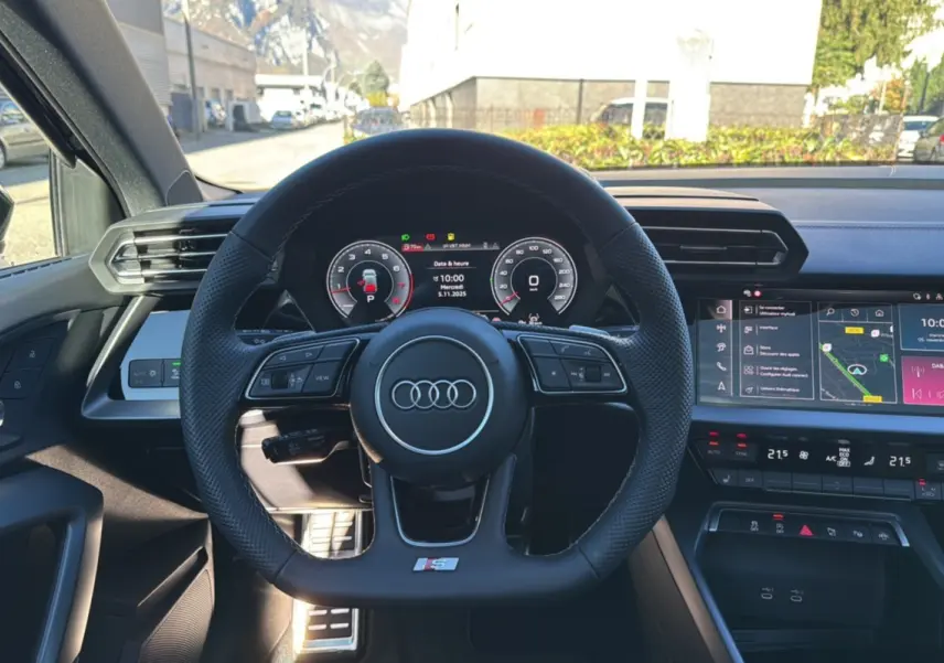 Vue centrée sur le volant cuir méplat Audi A3 S-Line 2025 avec tableau de bord digital et écran tactile couleur.