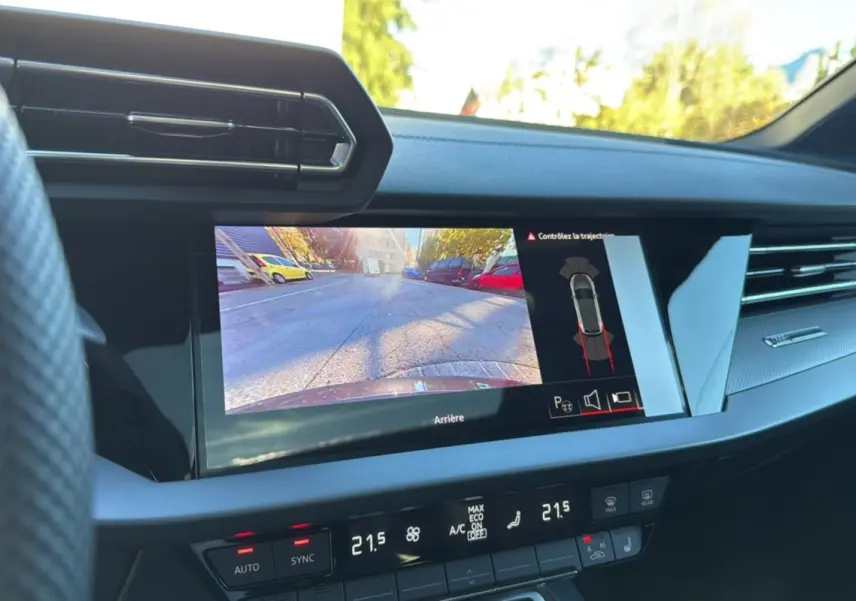 Vue intérieure du tableau de bord de l'Audi A3 2025 noir mythic avec écran caméra de recul et climatisation digitale.