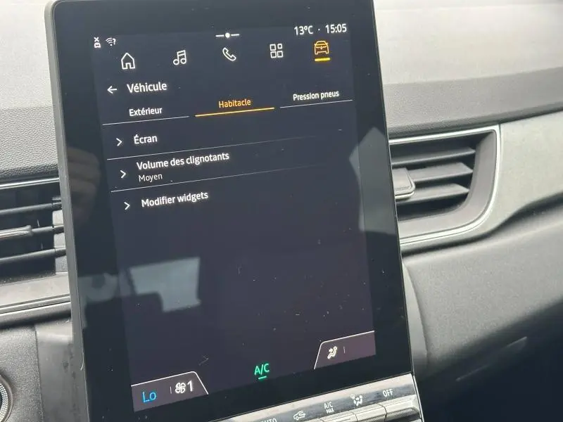 Écran tactile central du tableau de bord du Renault Captur 2025, affichant les réglages du véhicule.