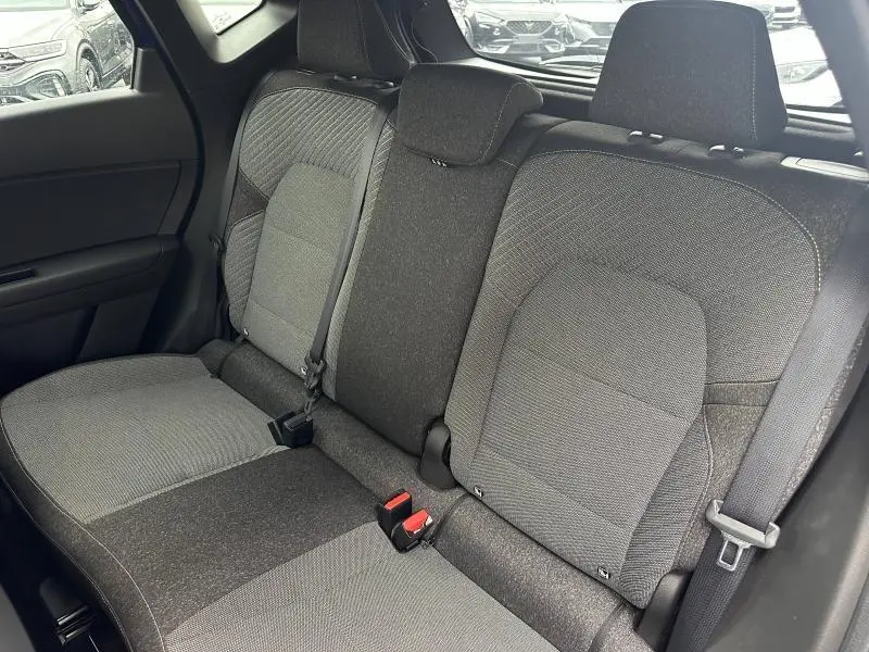 Vue intérieure côté droit de la banquette arrière grise du Renault Captur 2025 avec ceintures et appuie-têtes intégrés.