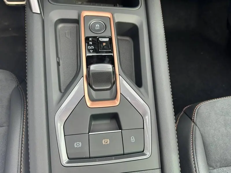 Gros plan sur la console centrale du CUPRA Formentor 2026 avec levier de vitesse automatique et cadre cuivre, intérieur noir.