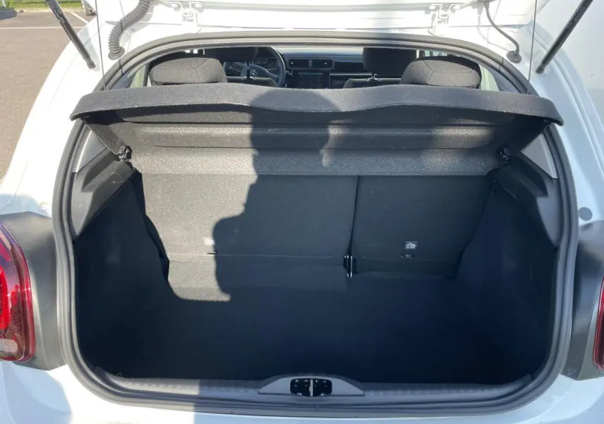 Coffre ouvert vu de l'arrière d'une Citroën C3 blanche banquise, montrant l'espace de chargement et la banquette arrière.