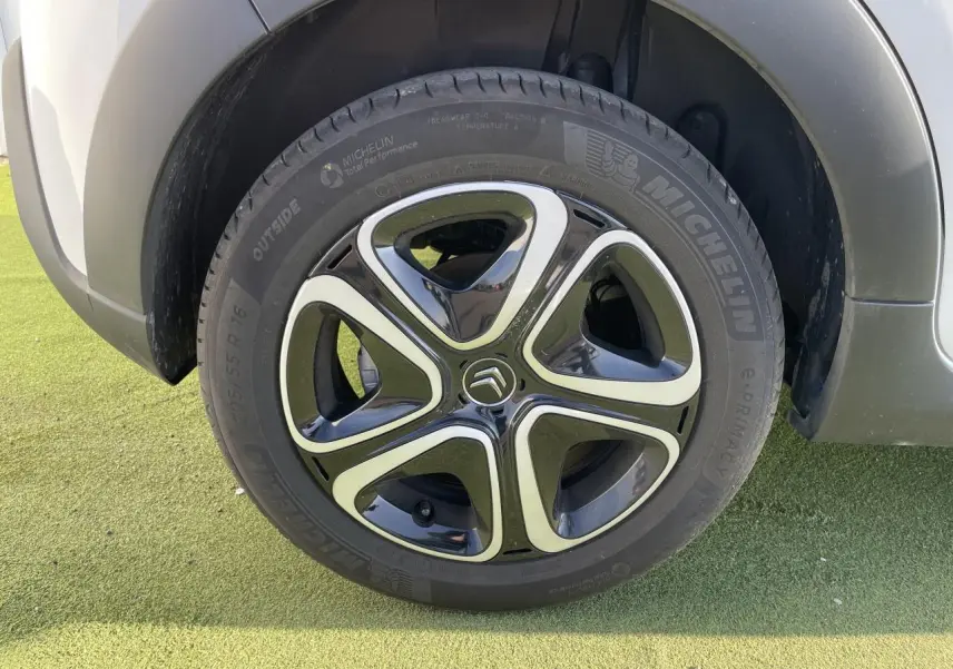 Gros plan sur la roue avant droite de la Citroën C3 blanche avec jante alliage noire et argentée au design moderne.